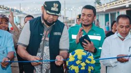Bupati Halmahera Selatan, Hasan Ali Bassam Kasuba, memotong pita tanda diresmikannya Kawasan Ekonomi Desa Kawasi. (Dok. Harita Nickel)