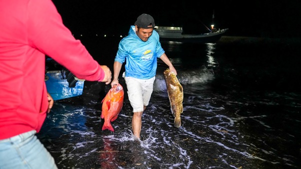 Peserta membawa ikan hasil tangkapannya menuju pos timbang untuk dicatatkan panitia.