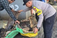 Bhabinkamtibmas bersama lurah melakukan pembersihan trotoar.