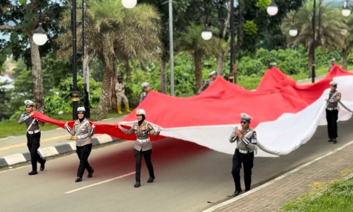 Sat Lantas Polres Halteng Bentangkan Dan Bagikan Bendera Merah Putih Sambut HUT RI Ke-80 