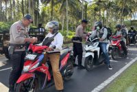 Personil Mako Brimob Kupa-Kupa bagikan bendera merah putih.