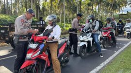 Personil Mako Brimob Kupa-Kupa bagikan bendera merah putih.