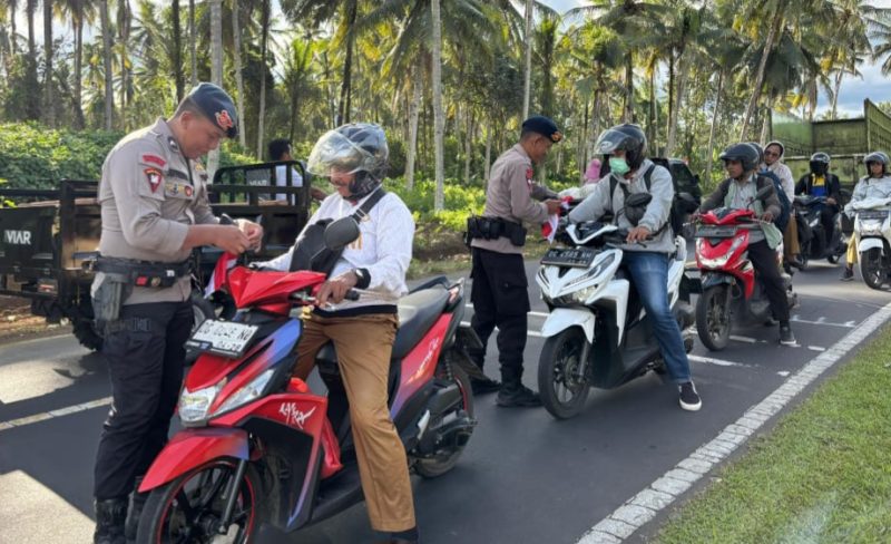 Personil Mako Brimob Kupa-Kupa bagikan bendera merah putih.