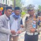 Kanit Rekiden Ipda Rucky Richardo bersama persinil Satlantas Polres Halut bagikan air mineral ke masa aksi.(istimewa)